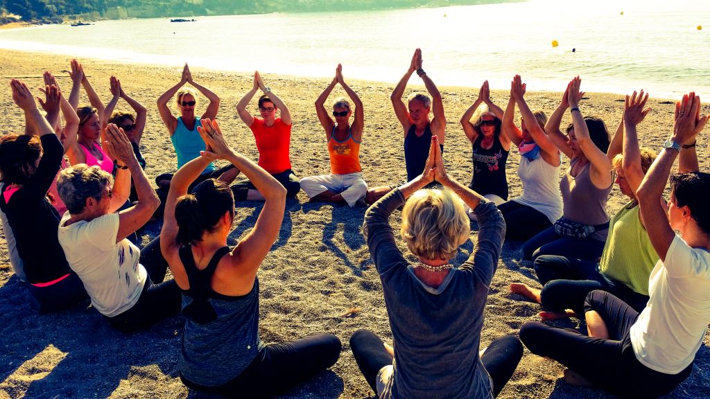 Gruppe übt eine Yogahaltung während eines Retreats