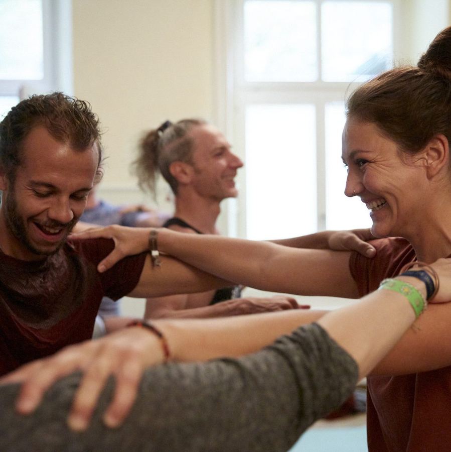Teilnehmende lachen sich bei einer Partnerübung an