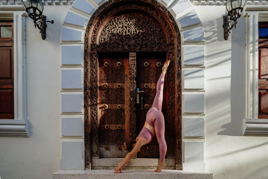 Frau praktiziert Yoga vor historischem Gebäude